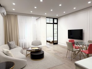 Una sala de estar moderna con un sofá, una mesa redonda de centro y un televisor.