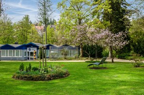 A garden area with a bench, a pathway, and a building with a blue roof.