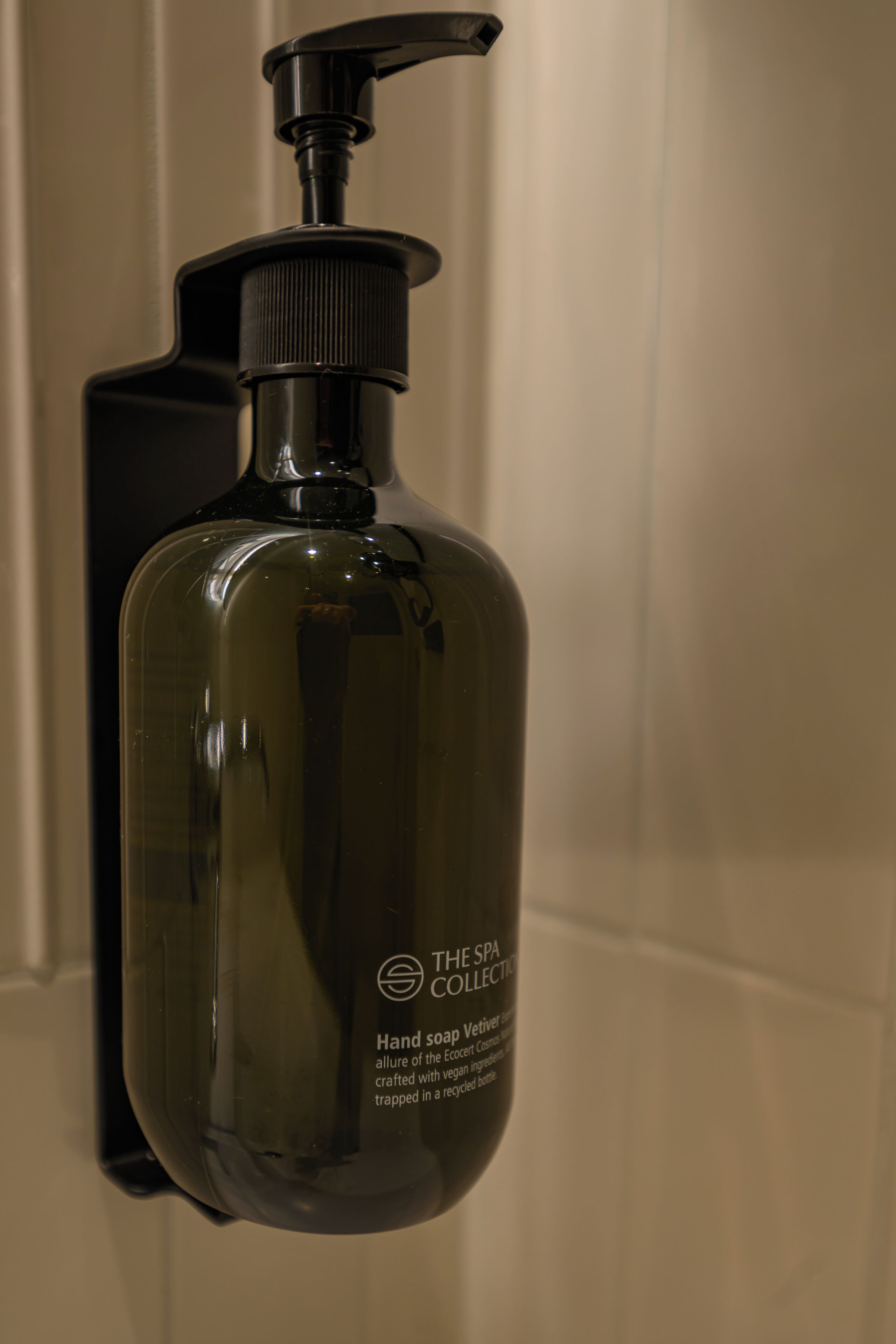 A hand soap dispenser with a pump, labeled 'The Spa Collection,' in a bathroom setting.