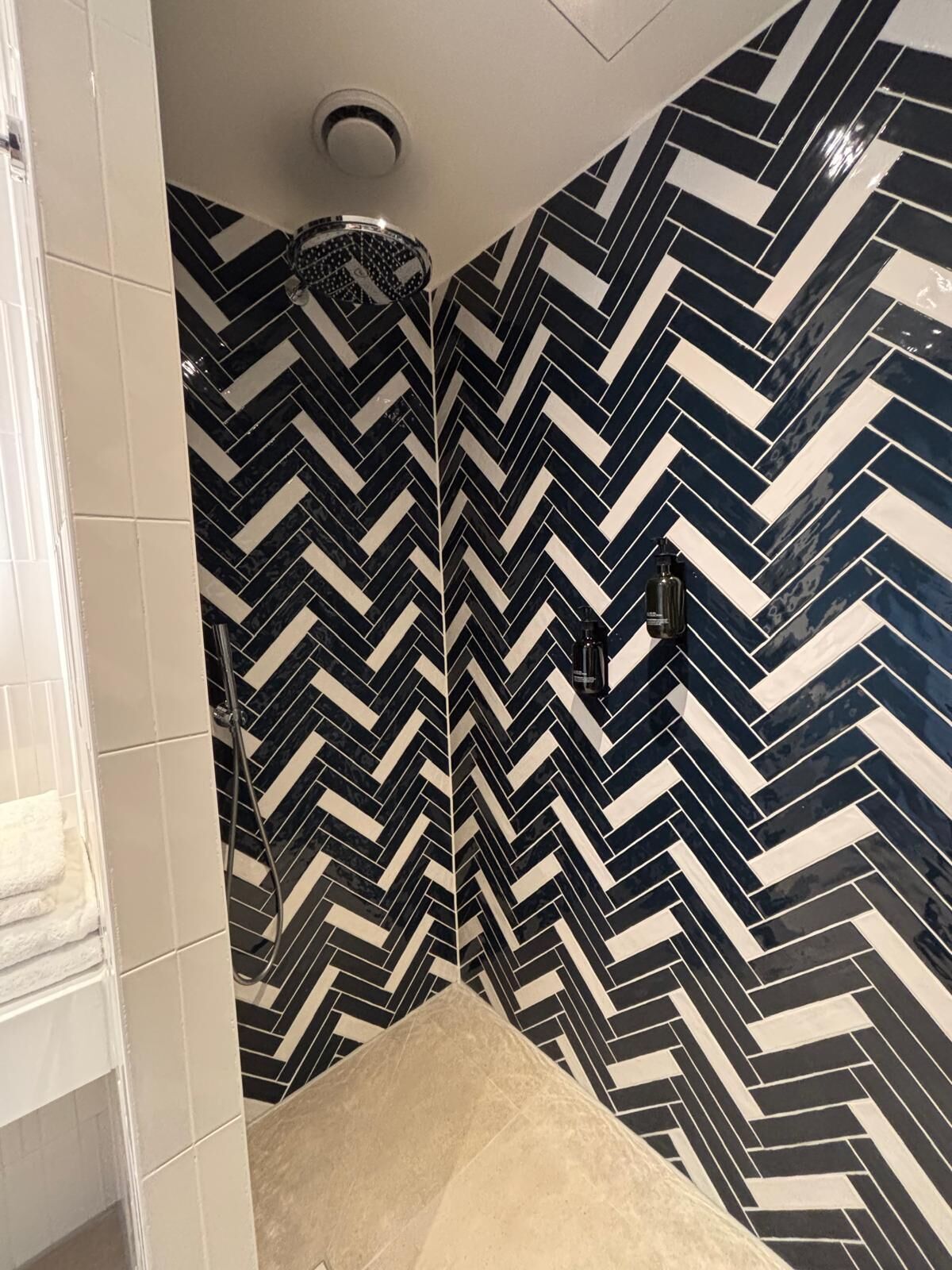 Un baño con un estampado de chevron blanco y negro en las paredes y el suelo.