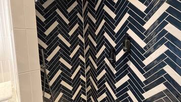 Un baño con un estampado de chevron blanco y negro en las paredes y el suelo.