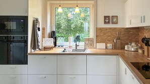 Cafetera o tetera, frigorífico, microondas y placa de cocina