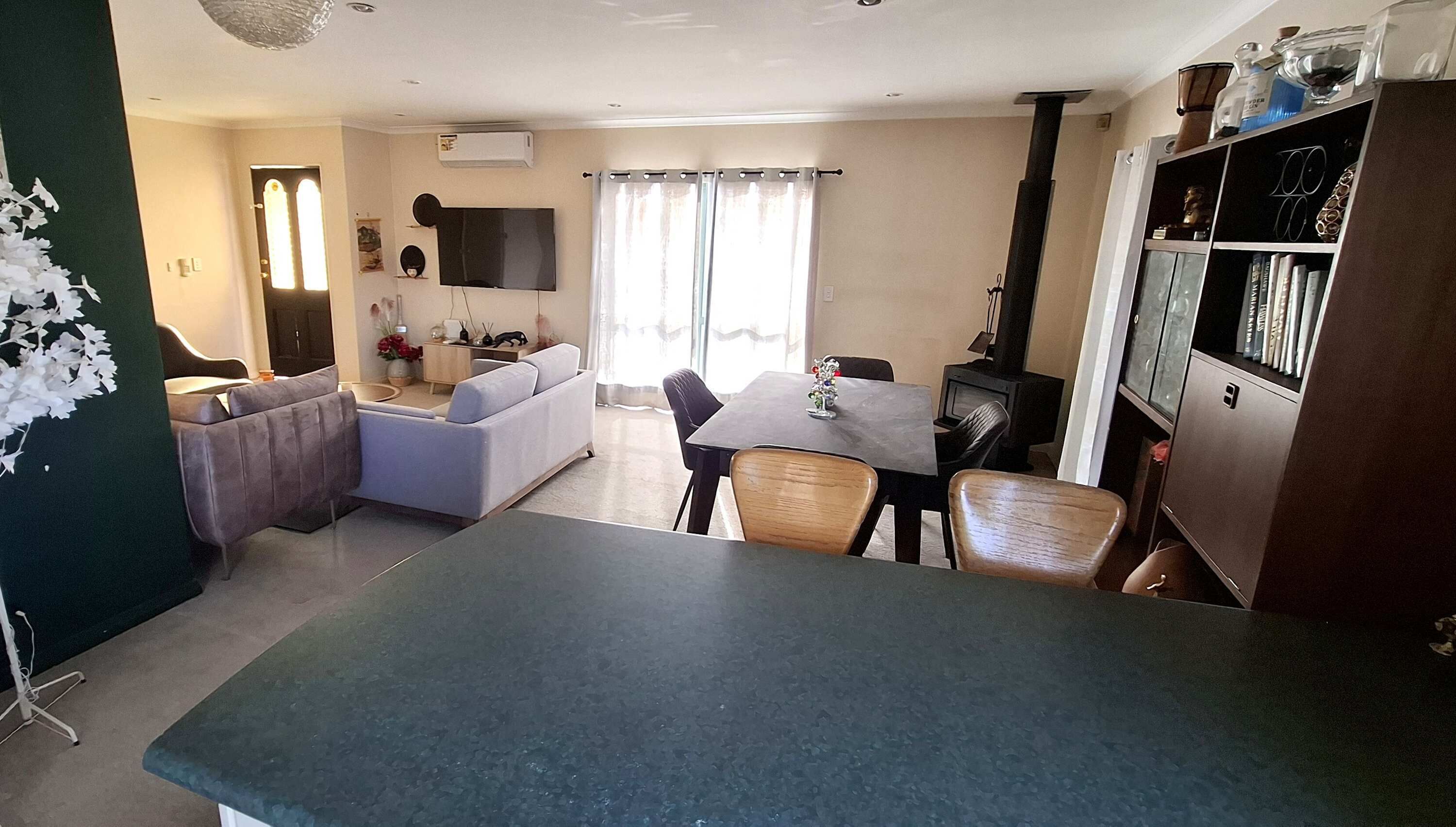 A living room with a sofa, a dining table with chairs, a TV, and a fireplace.
