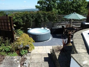 An outdoor hot tub area with a patio, seating, and a view of the landscape. - 2 Bed in Banwell (oc-29452) (Banwell)