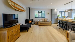Una sala de estar moderna con televisor, sofá y chimenea.