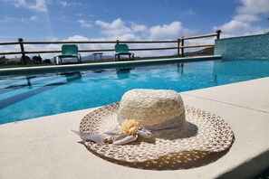 Ein Poolbereich mit einem gewebten Hut und Accessoires am Boden.