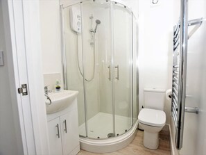 A modern bathroom with a glass-enclosed shower, a white sink, and a toilet. - 3 Bed in Ferryside (oc-53442) (Ferryside)