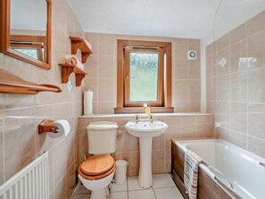 Een badkamer met toilet, wastafel en bad.