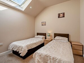 A bedroom with two beds, a skylight, and a nightstand with a lamp. - 2 Bed in Blakeney (oc-54765) (Awre)