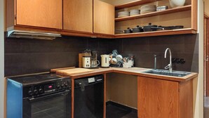 Una cocina compacta con estufa, lavavajillas y pileta.