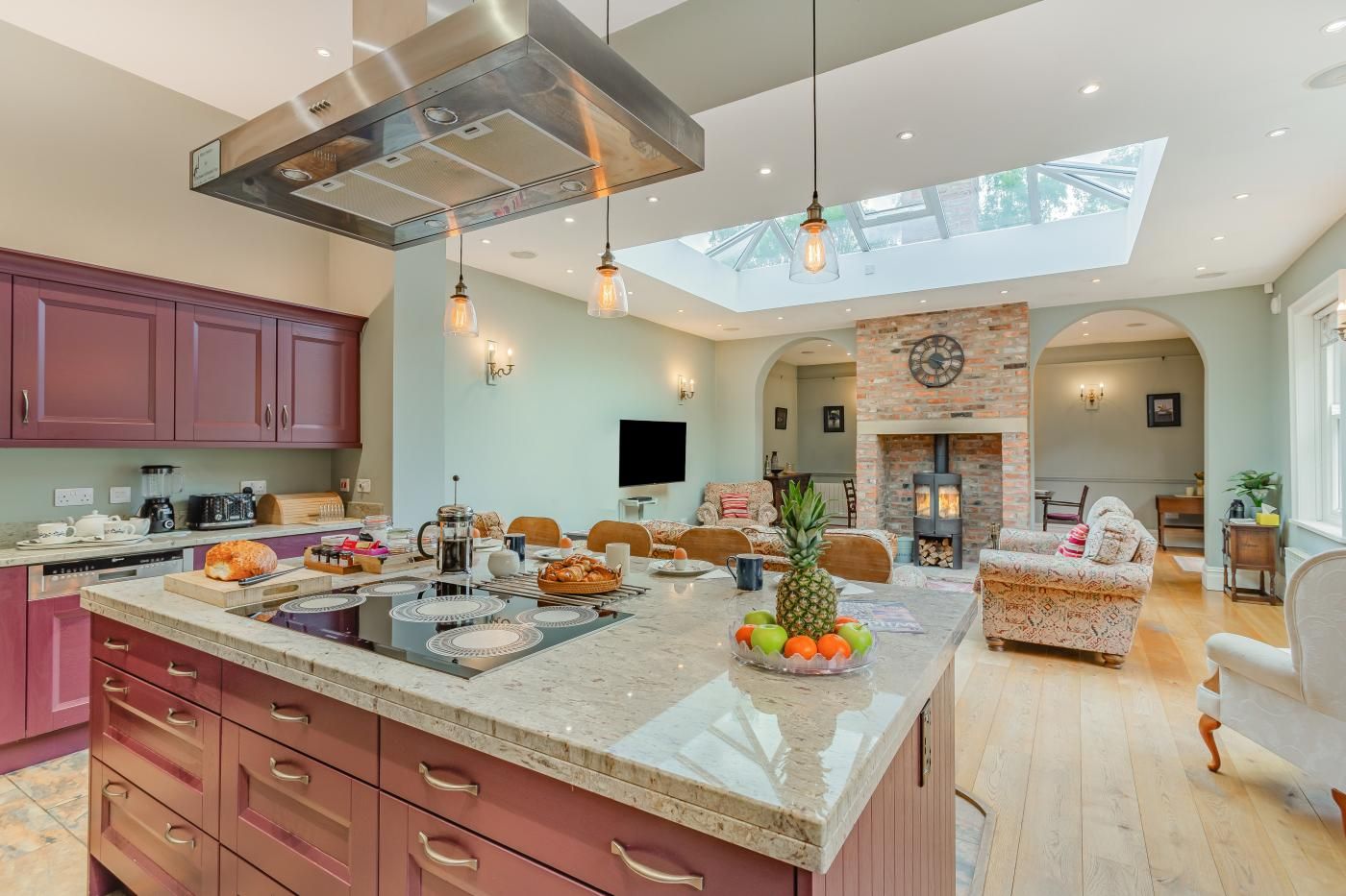 A spacious kitchen with a large island, modern appliances, and a skylight.