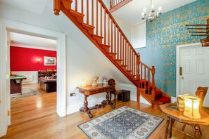 A staircase with wooden balusters leading to a landing, a patterned rug, and a table with a lamp. - 4 Bed in York (oc-55738) (Elvington)