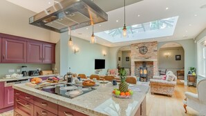 A spacious kitchen with a large island, modern appliances, and a skylight. - 4 Bed in York (oc-55738) (Elvington)