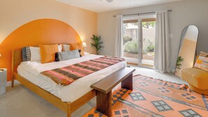 A bedroom with a bed, a bench, a ceiling fan, a window with curtains, and a view of the outdoors. - Chic 5BR, Yard, Mtn Views, Games 4 fun Family time (Albuquerque)