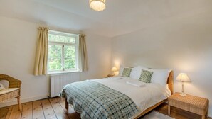 A bedroom with a bed, a window, a chair, a bedside table, and a lamp. - 4 Bed in Lyndhurst (oc-57407) (Lyndhurst)