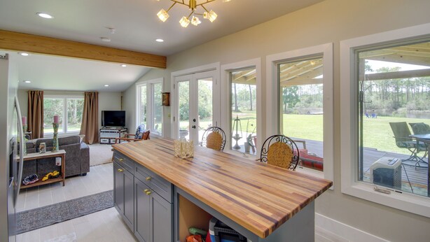 A modern kitchen with a wooden countertop, built-in cabinets, and a ceiling light fixture. - Private Ocean Springs Waterfront Retreat w/Porch (Ocean Springs)