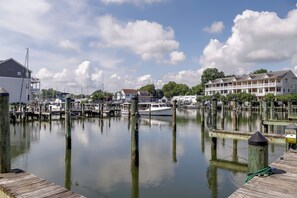 Un port de plaisance avec des bateaux amarrés, des quais en bois et des immeubles résidentiels en arrière-plan.