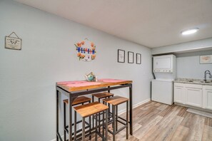 A kitchen with a bar stool, a washing machine, and a refrigerator. - 6 Mi to Dtwn: Family-Friendly Knoxville Apartment (Knoxville)