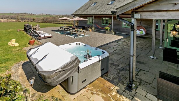 Ein Whirlpool, Sitzgelegenheiten im Freien und eine Holzterrasse.