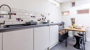 A modern kitchen with white cabinets, a grey countertop, a black sink, and a window above the sink. - 2 Bed in Ellesmere (oc-62544) (Dudleston Heath)