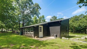 A single-story building with a garage door, a front porch, and a small front yard with grass and rocks. - ATV and Boating Base! Home Under 1 Mi to Grand (Disney)