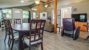 A spacious living area with a dining table, chairs, a sofa, a recliner, a TV, and a ceiling fan. - ATV and Boating Base! Home Under 1 Mi to Grand (Disney)