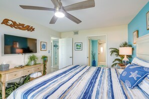 A bedroom with a bed, a ceiling fan, a television, and a door leading to another room. - Right on the beach!South Padre Island Luxury stay! (South Padre Island)