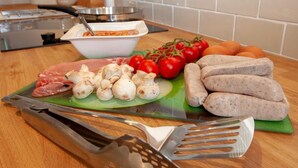 A kitchen counter with raw meat, mushrooms, tomatoes, and sausages. - 2 Bed in Richmond (oc-74284) (Reeth)