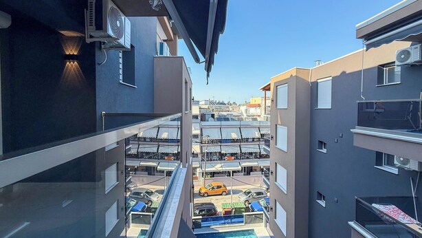 Un edificio residencial con piscina, balcones y unidades de aire acondicionado.