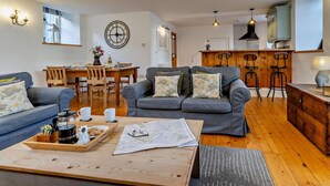 Ein gemütliches Wohnzimmer mit einer Couch, einem Couchtisch und einem Essbereich mit Stühlen und einem Tisch.