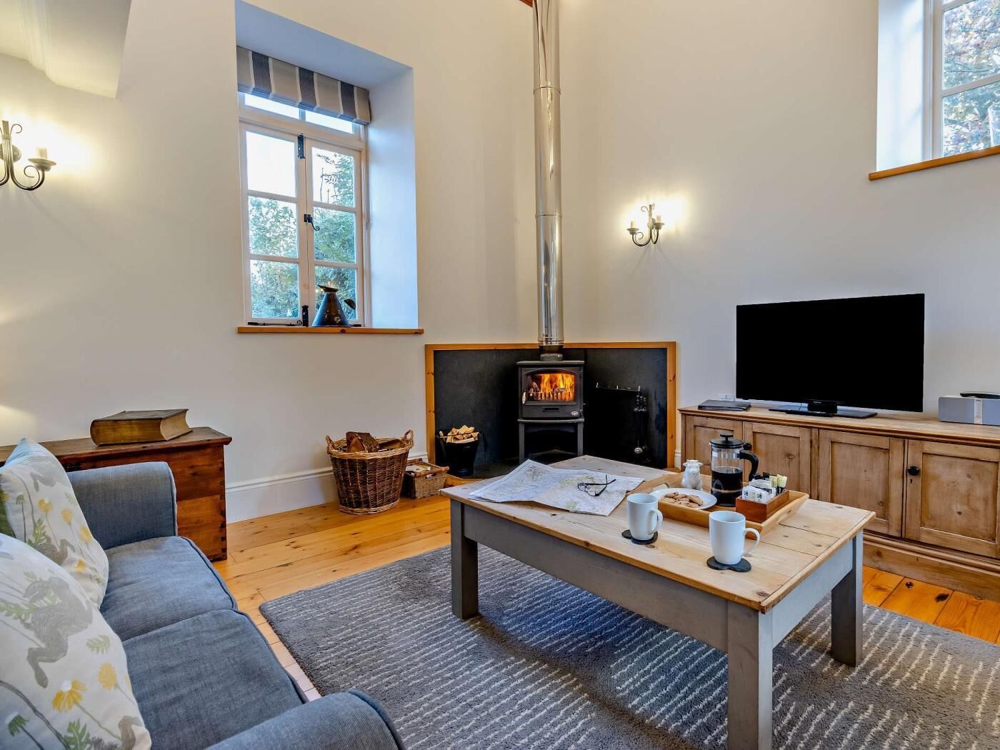A cozy living room with a fireplace, a sofa, a coffee table, and a television.