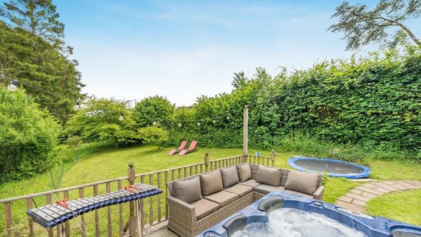 A hot tub, a sofa, and a trampoline in a backyard. - 2 Bed in Beaworthy (oc-77555) (Black Torrington)