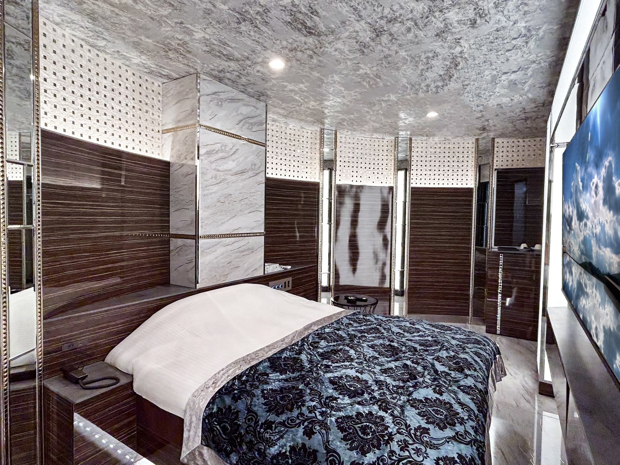 Quarto moderno com cama, guarda-roupa e um espelho grande.