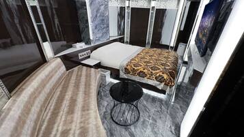 A modern room with a bed, a small table, and a chair.