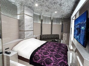 A modern hotel room with a large bed, a sofa, a TV, and a cityscape view. - hotel CenturyANNEX (Chiba)