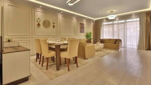 Een moderne woonkamer met een eethoek, een bank en een salontafel.