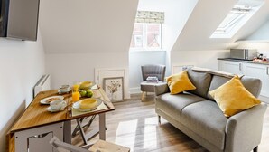 Een modern appartement met een eethoek, een bank en een keuken.