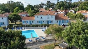 Ein Wohngebiet mit Swimmingpool, Liegestühlen und einem umzäunten Deckbereich.