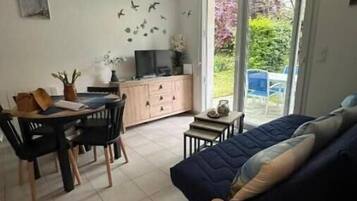 A room with a bed, a desk, a chair, and a television.