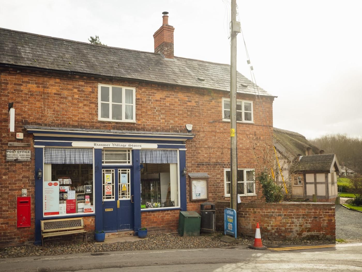 A brick building with a blue storefront labeled 'Banner Village Stores.'