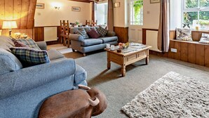 Ein gemütliches Wohnzimmer mit einer Couch, einem Couchtisch und einem Teppich.