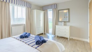 Ein Schlafzimmer mit Bett, Kleiderschrank, Schminktisch und Spiegel.