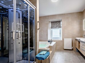 A modern bathroom with a glass-enclosed shower, a bathtub, and a window with a view.