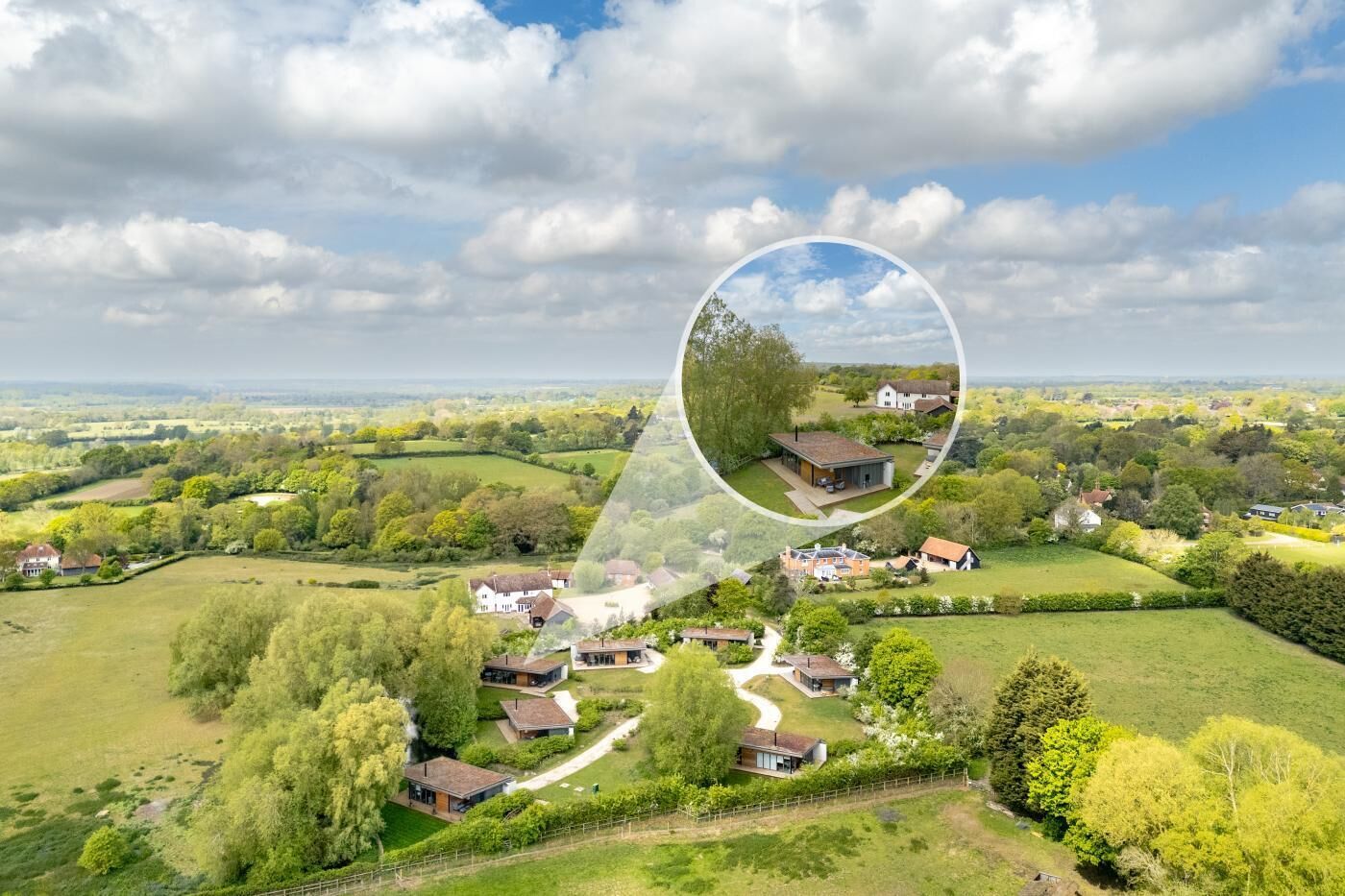 An aerial view of a rural area with houses, roads, and greenery.