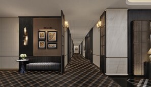 A corridor with a checkered floor, framed artwork on the walls, and a bench with a vase of flowers. - Wuhan Riverside Maxx Hotel (Wuhan)