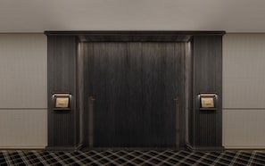 A dark wooden door with two plaques, one on each side, and a checkered floor pattern. - Wuhan Riverside Maxx Hotel (Wuhan)