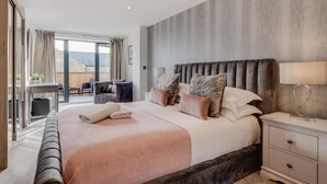 A modern hotel room with a large bed, bedside tables, a desk, and a view of the outdoors. - 4 Bed in Richmond (oc-83250) (Richmond)