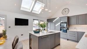 A modern kitchen with a central island, grey cabinets, a built-in oven, and a large window. - 4 Bed in Richmond (oc-83250) (Richmond)