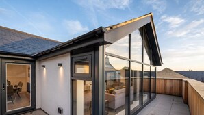 A modern rooftop terrace with glass walls, a dining area, and a view of the cityscape. - 4 Bed in Richmond (oc-83250) (Richmond)