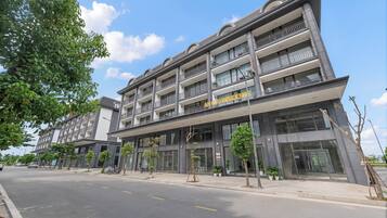 A multi-story hotel with a modern facade, balconies, and a clear sky.
